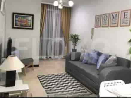 Ruang tamu modern dengan sofa abu-abu, karpet berpola, dan karya seni berbingkai di dinding.
