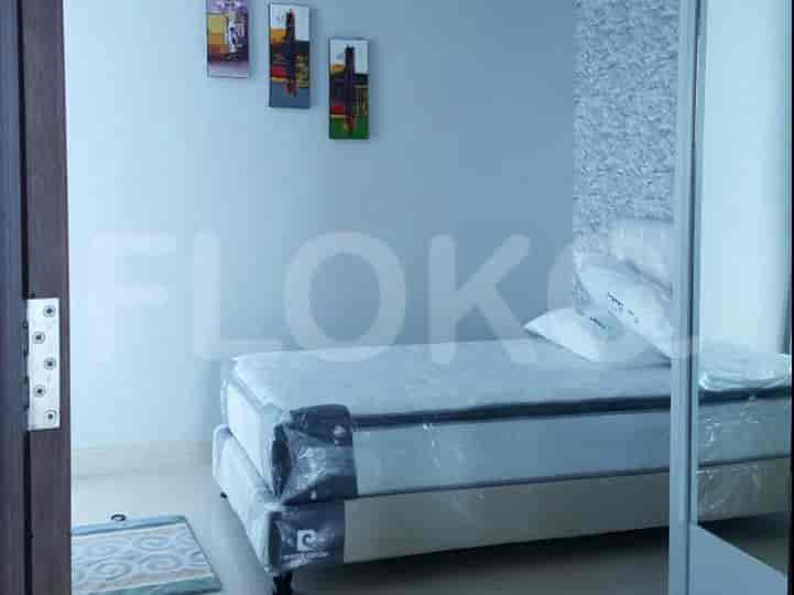 Kamar tidur dengan tempat tidur single dan karya seni di dinding.