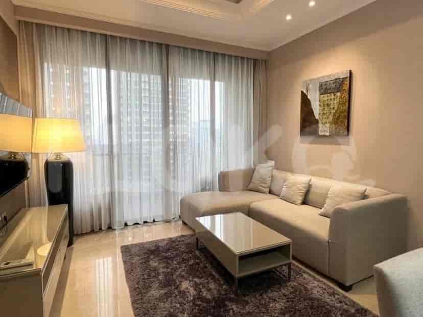 Ruang tamu modern dengan sofa sectional, meja kopi, dan jendela besar dengan gorden tipis.