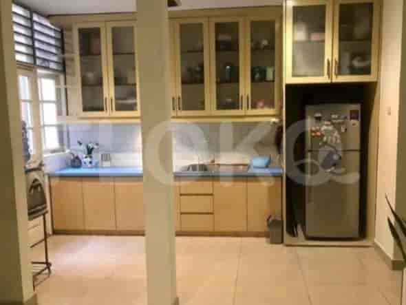 A kitchen with wooden cabinets, a refrigerator, and a window.