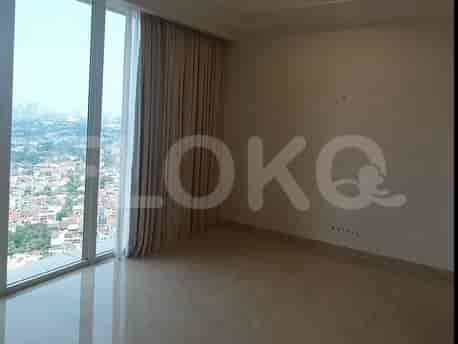 An empty bedroom with a large window offering a city view and beige curtains.