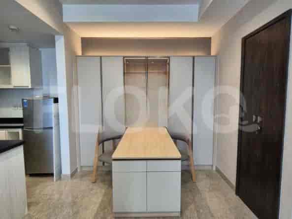 Dining area with a light-colored dining table and chairs, and storage cabinets.