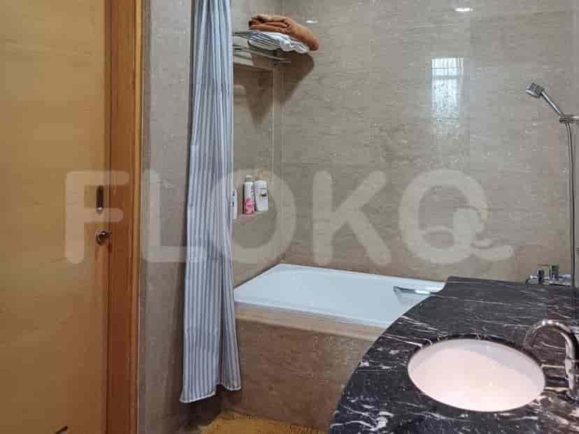 A bathroom with a bathtub, sink, and marble vanity.