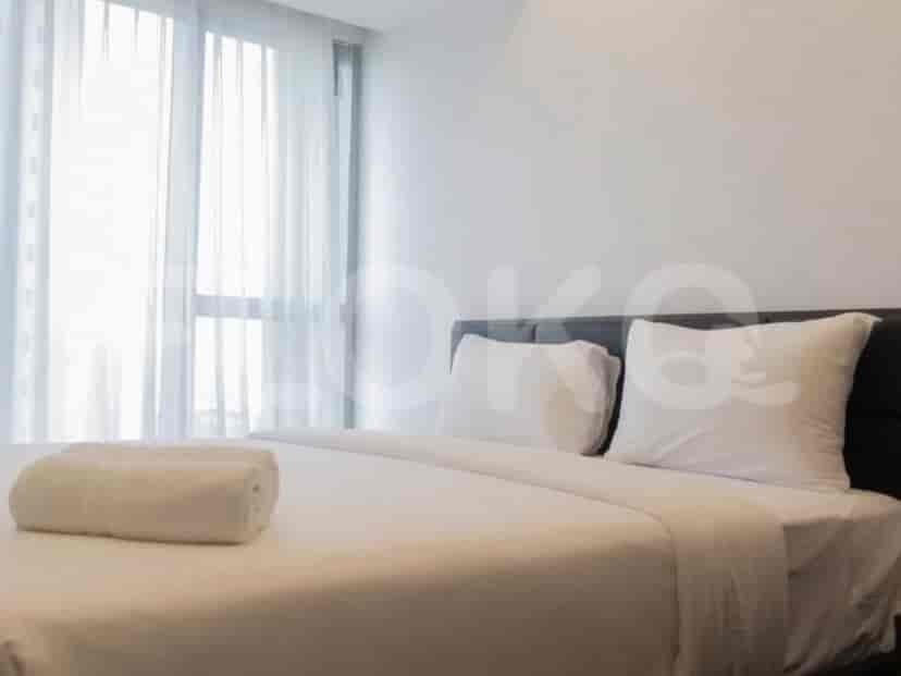 Sebuah kamar tidur dengan tempat tidur, bantal, dan handuk yang digulung.