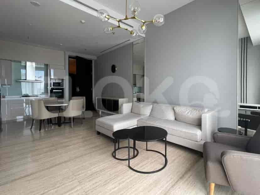 A modern living room with a sectional sofa, coffee table, and a view of the dining area.