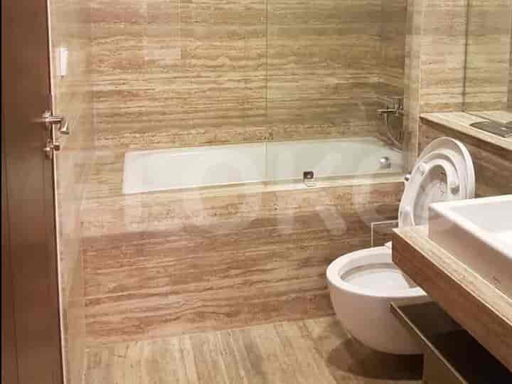 Bathroom featuring a bathtub, toilet, and marble wall design.
