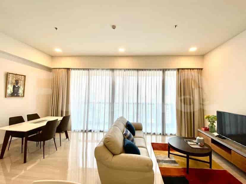 A living room with a large window, sofa, coffee table, dining table, and chairs.