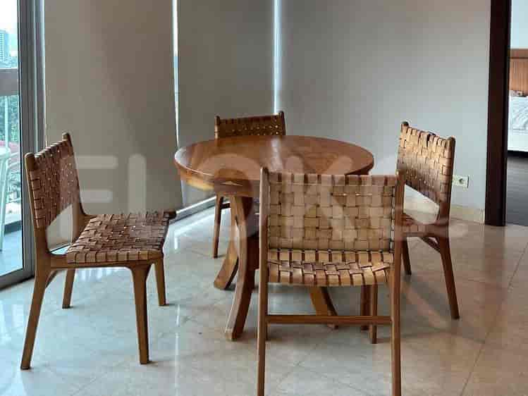 A round wooden dining table with four chairs.