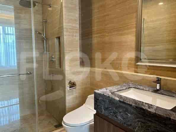 A modern bathroom with a walk-in shower, marble walls, and a dark marble countertop.