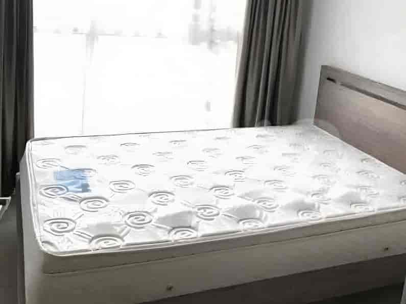 Tampilan dekat tempat tidur dengan kasur putih di ruangan dengan rangka tempat tidur kayu dan gorden.