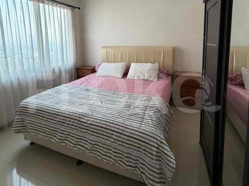 A bedroom with a queen-size bed, bedside tables, and a large wardrobe.