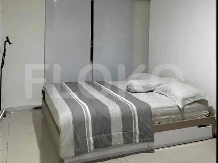 A bedroom with a queen-sized bed and a striped duvet, next to a mirrored sliding closet.
