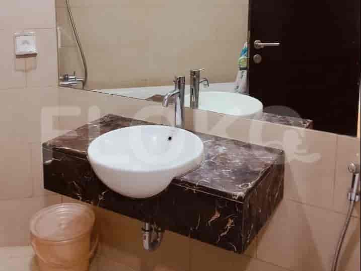 A bathroom with a sink, mirror, and a faucet.