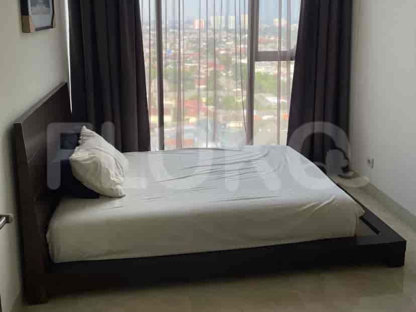 Kamar tidur dengan tempat tidur ukuran queen, kepala tempat tidur kayu gelap, dan jendela besar dengan tirai gelap.