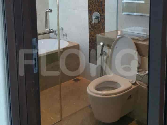 A modern bathroom with a toilet, bathtub, and shower.