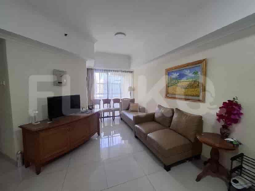 A living room with a sectional sofa, wooden TV console, and a painting on the wall.