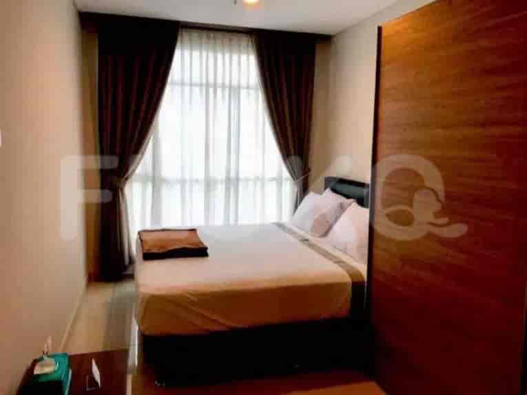 A bedroom with a queen-sized bed, dark brown curtains, and a wooden wardrobe.