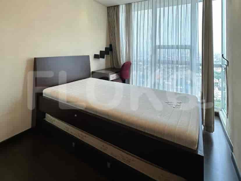 A bedroom with a twin bed with a pull-out, a desk with a chair, and a large window with curtains.