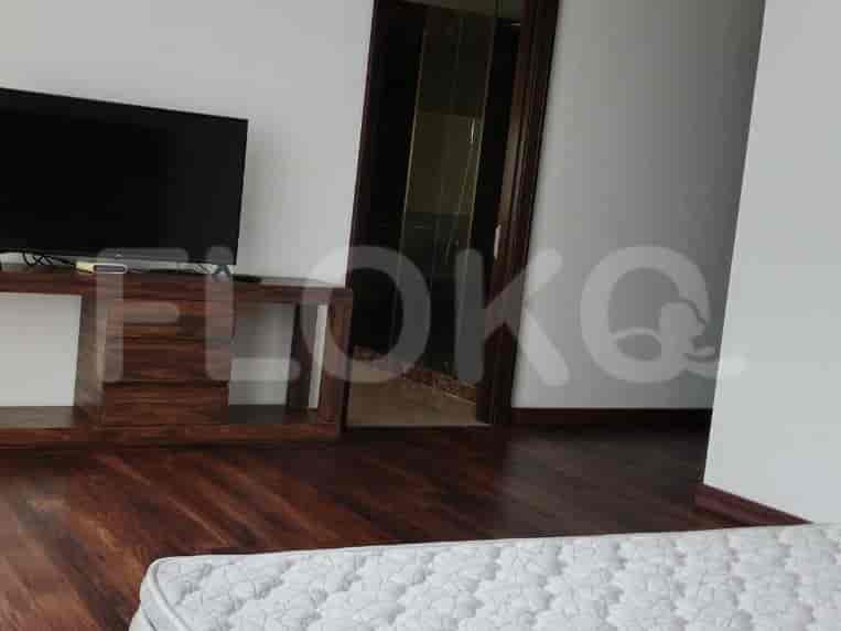 Bedroom with a flat-screen TV and wooden TV stand.