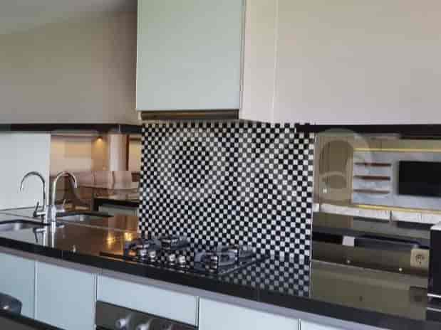 Dapur modern dengan backsplash motif kotak hitam putih, peralatan stainless steel, dan kompor gas.
