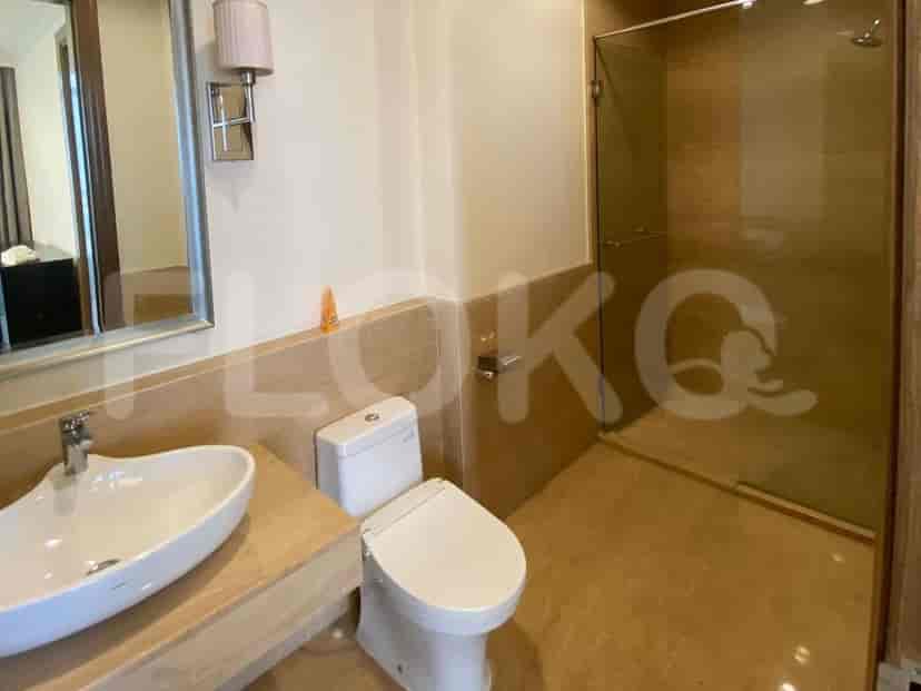 A modern bathroom with a vanity, toilet, and a glass-enclosed shower.