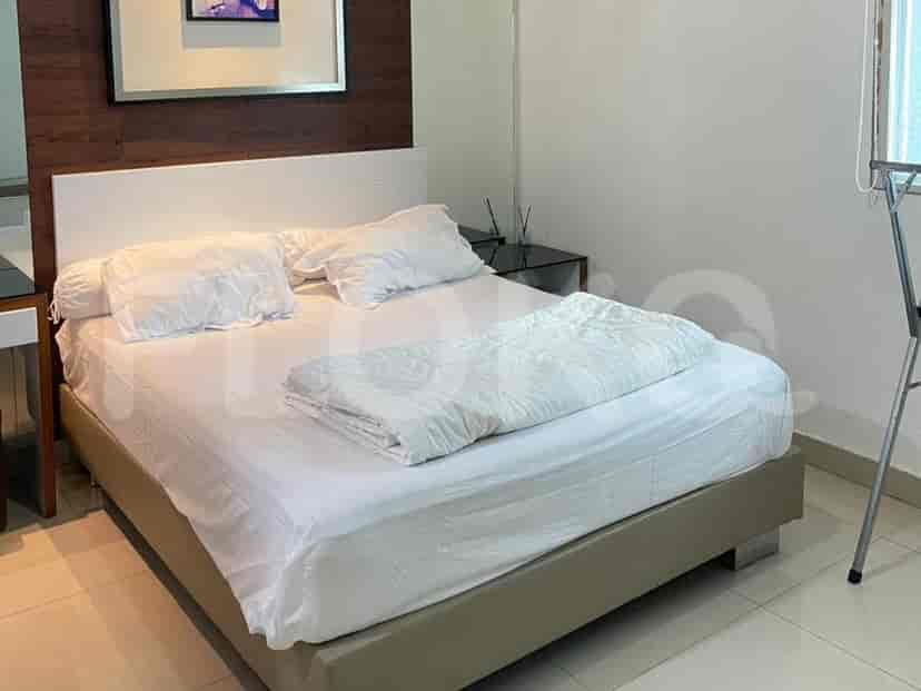 A bedroom with a queen-size bed, white bedding, and a wooden accent wall.