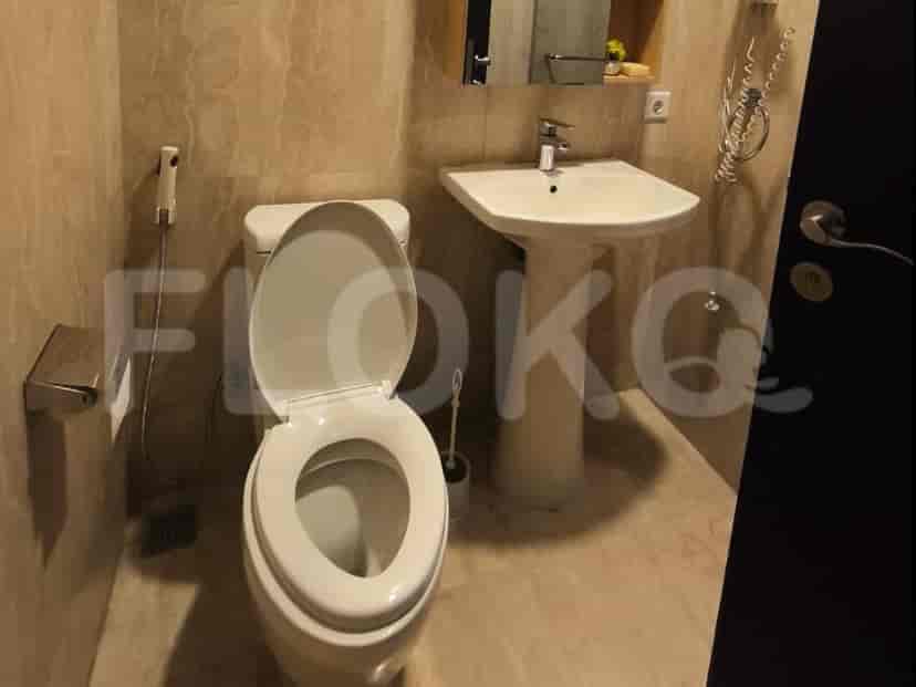 A bathroom with a toilet, pedestal sink, and a bidet spray.