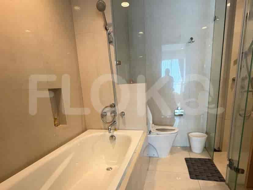 A modern bathroom featuring a bathtub, a glass-enclosed shower, and a toilet.