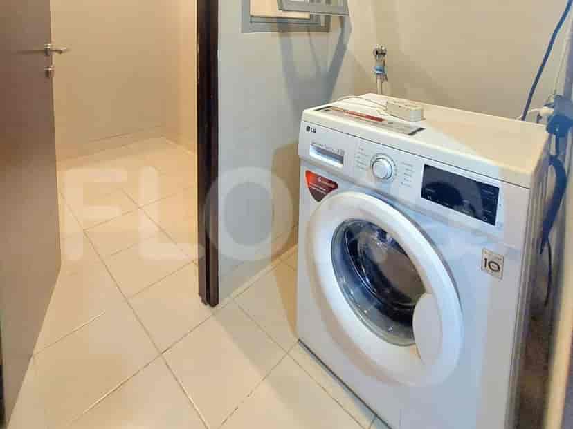 Laundry room with washing machine and drying rack.
