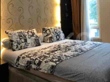 Bedroom with a double bed, patterned bedding, and wallpaper.