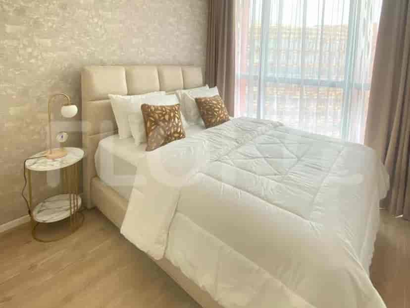 A bedroom with a large bed, bedside table, and a lamp.