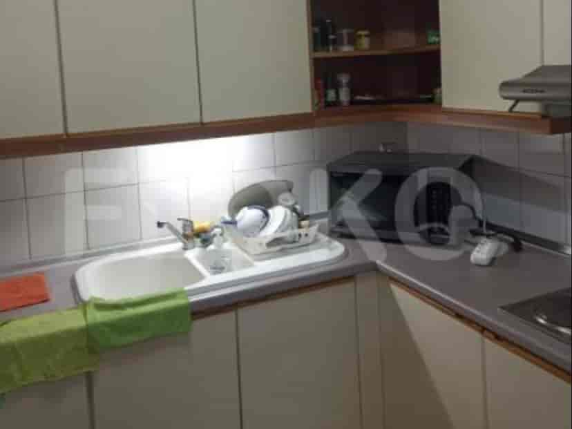 A compact kitchen with cabinets, a sink, and a microwave.