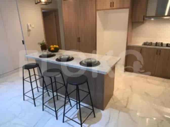 A modern kitchen island with seating, alongside a wooden cabinet and kitchen setup.