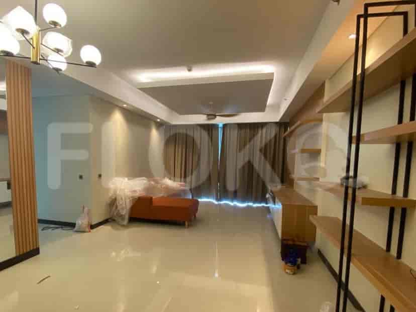 Ruang tamu luas dengan sofa modular berwarna oranye, tirai besar, dan rak kayu.