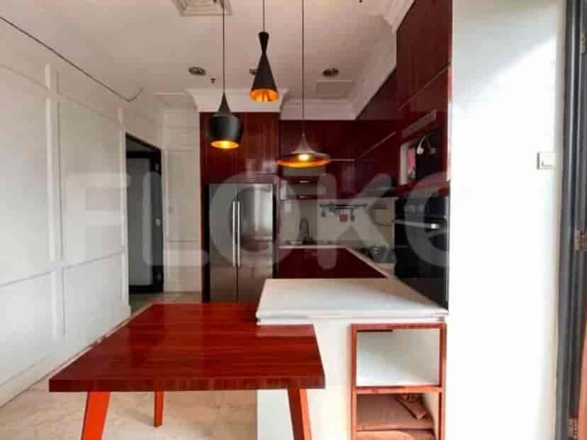 A compact kitchen with dark red cabinetry, stainless steel appliances, and a breakfast bar.