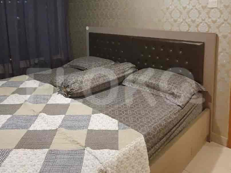 A cozy bedroom featuring a bed with a padded headboard and patterned bedding.