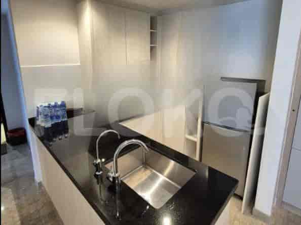 A modern kitchen with a black countertop and stainless steel sink.