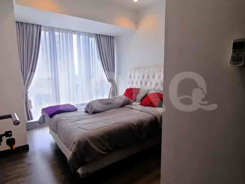 A stylish master bedroom with a large bed and large windows.