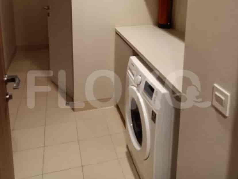 A laundry area with a washing machine and storage.