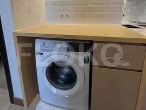 A washing machine set up in the kitchen.