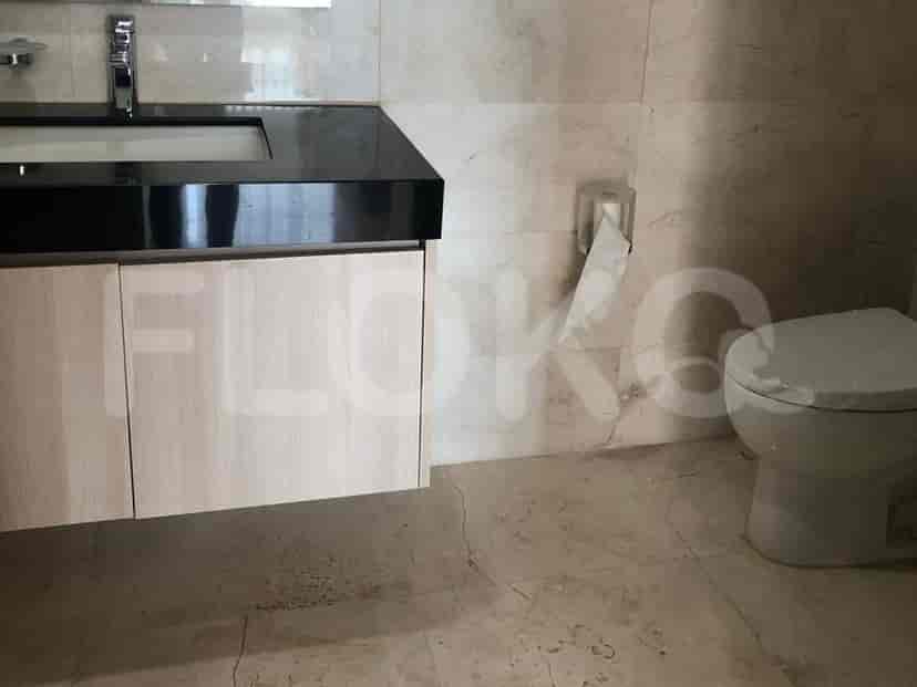 Bathroom with a toilet, sink, and black countertop.