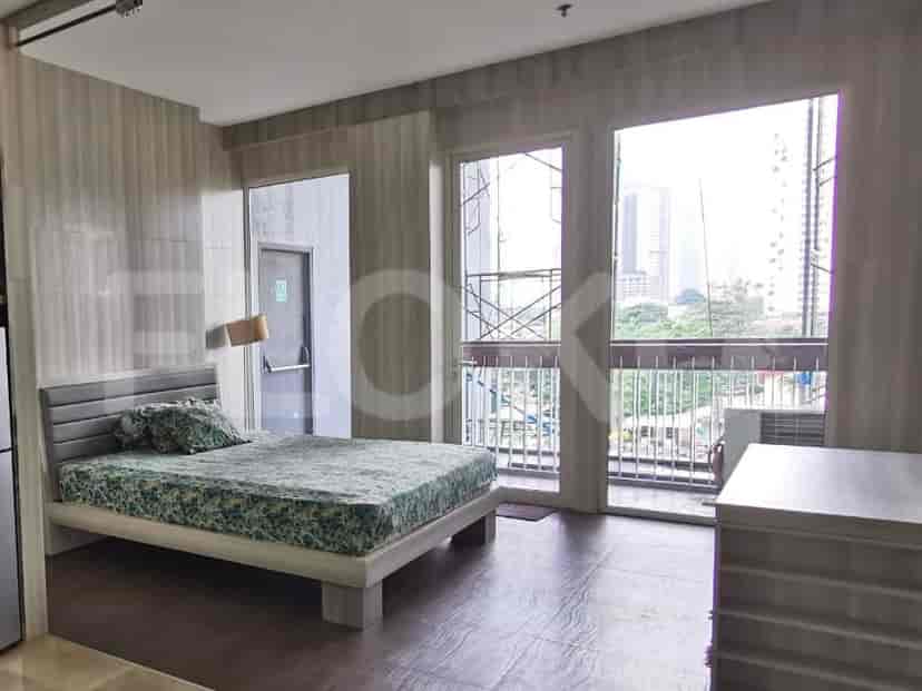 A bedroom with a queen-size bed, patterned beddings, and a large window with a city view.