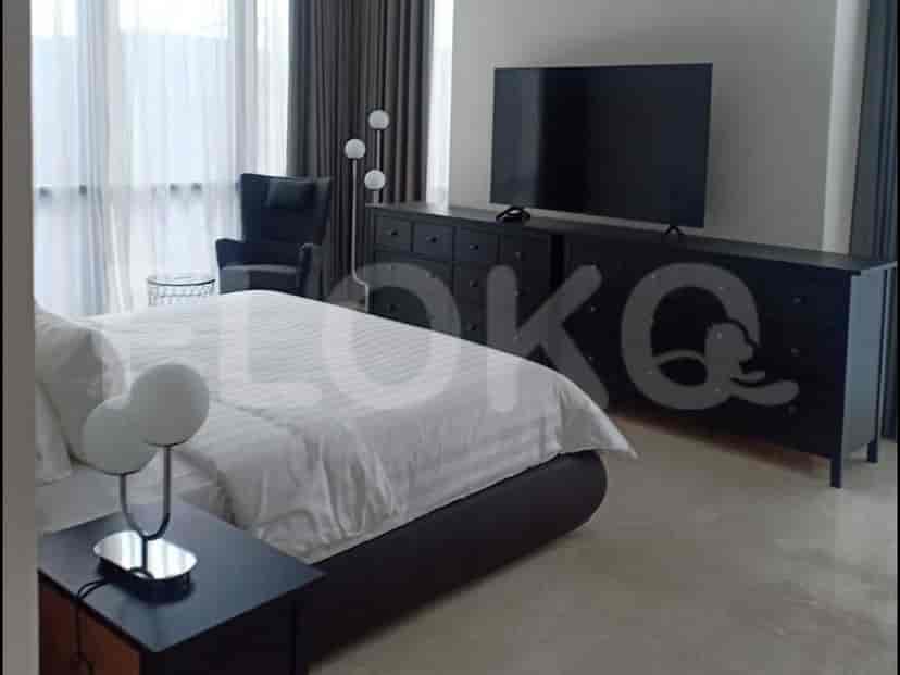 A bedroom with a TV, a bed, a chair, and a dresser.