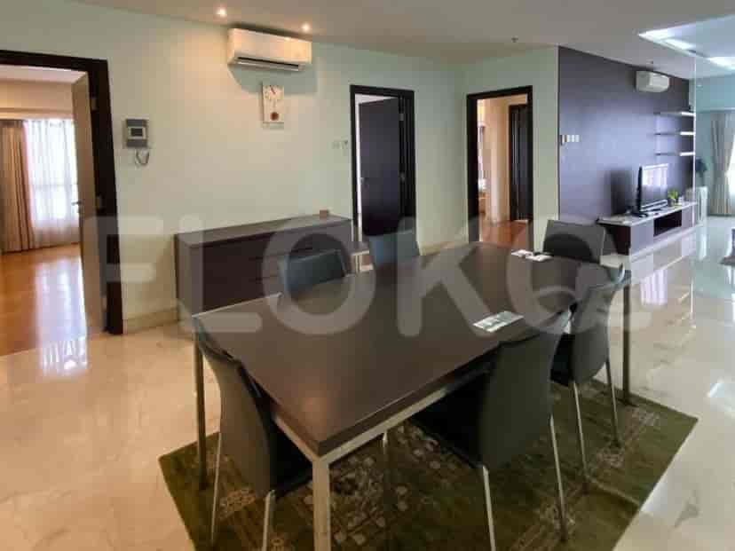 A dining area with a dark wood table and chairs, adjacent to a hallway.