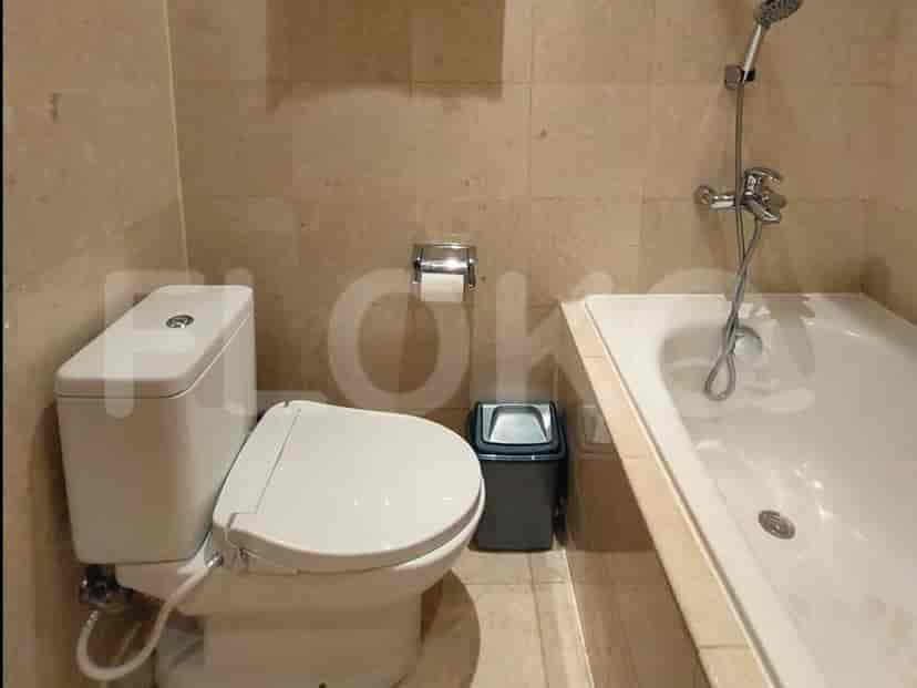 A bathroom with a toilet, a bidet function toilet seat, and a bathtub.