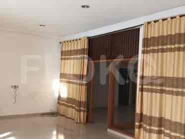 Tampilan area tamu yang menunjukkan pintu geser besar yang ditutupi gorden bermotif.
