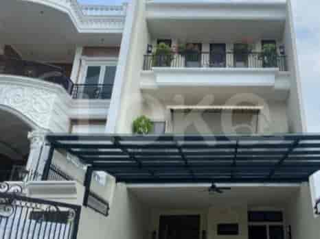 A modern three-story house with a carport, balcony, and decorative elements.