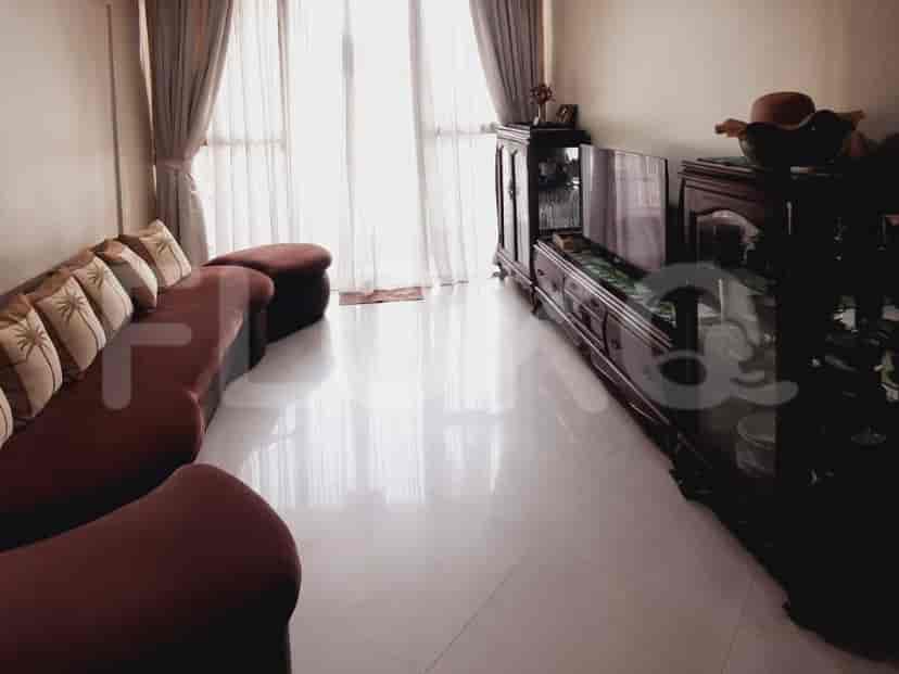 Living room with a red sofa, large windows, and a dark wooden entertainment center.