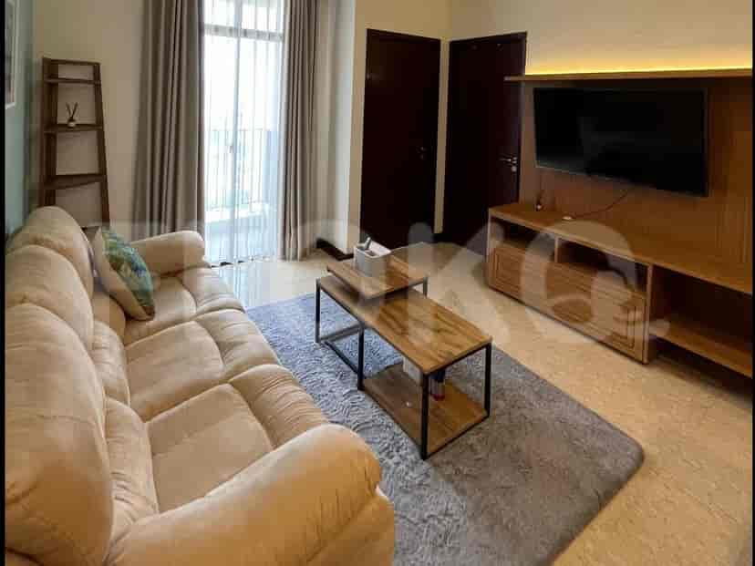 A living room with a sofa, coffee table, and artwork.