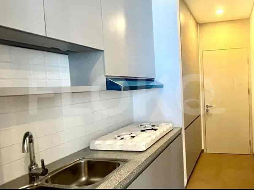 Dapur minimalis dengan lemari putih, kompor, dan wastafel baja tahan karat.